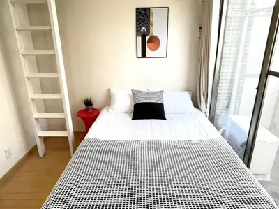 a small bedroom with a bed with a black and white comforter at \u30b7\u30e3\u30f3\u30c6\u9ad8\u7530\u99ac\u583442 in Tokyo