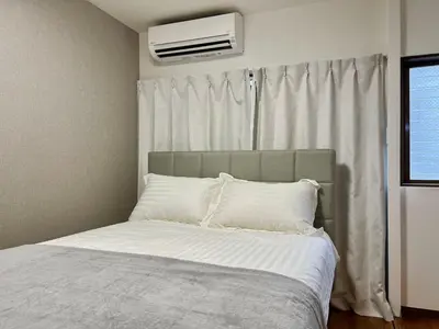 a bedroom with a bed with white sheets and a window at Kenki Asakusa House-TT0171 in Tokyo