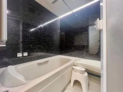 a bathroom with a white tub and a black wall at Kenki Asakusa House-TT0171 in Tokyo