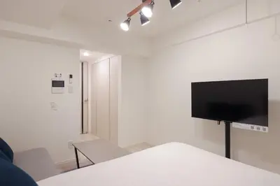 a white room with a flat screen tv on a wall at MAT Shinjuku West in Tokyo