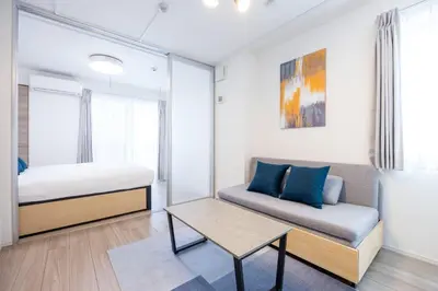 a bedroom with a bed and a couch and a table at skye yusima in Tokyo