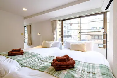 two beds with towels on them in a room with a window at \u30e9\u30f3\u30c9\u30d5\u30a9\u30ec\u30b9\u30c8\u4e21\u56fd - \u6d45\u8349\u3084\u30b9\u30ab\u30a4\u30c4\u30ea\u30fc\u8fd1\u304f- \u6700\u59276\u540d\u5bbf\u6cca\u53ef in Tokyo