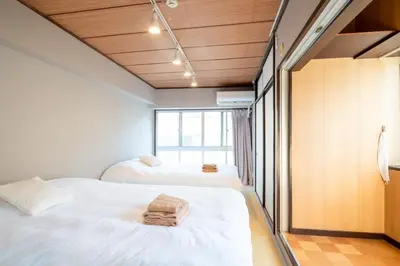 two beds in a room with a window at \u30b5\u30cb\u30fc\u30cf\u30a4\u30c4301 in Tokyo