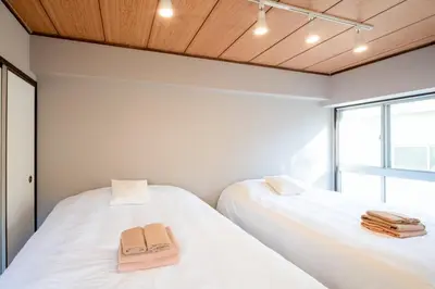 two beds in a room with two towels on them at \u30b5\u30cb\u30fc\u30cf\u30a4\u30c4301 in Tokyo