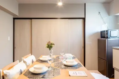 a dining room with a table and a refrigerator at \u30b5\u30cb\u30fc\u30cf\u30a4\u30c4301 in Tokyo