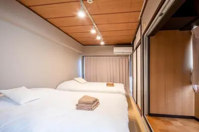 two beds in a small room with wooden ceilings at \u30b5\u30cb\u30fc\u30cf\u30a4\u30c4301 in Tokyo