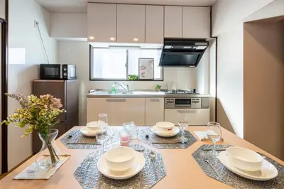 a kitchen with a table with plates and glasses on it at \u30b5\u30cb\u30fc\u30cf\u30a4\u30c4301 in Tokyo