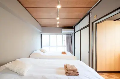 two beds in a room with a window at \u30b5\u30cb\u30fc\u30cf\u30a4\u30c4301 in Tokyo
