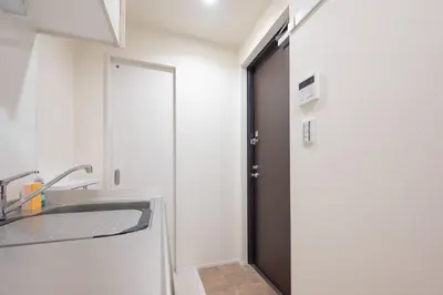 a bathroom with a sink and a mirror and a door at K-room in Tokyo