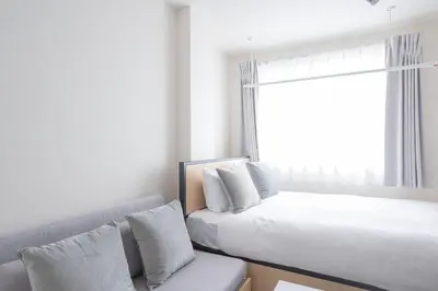 a bedroom with a bed and a couch and a window at K-room in Tokyo