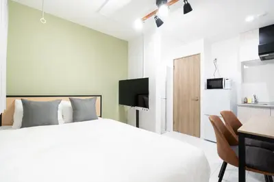 a bedroom with a bed and a desk and a tv at Luna\u4e21\u56fd in Tokyo