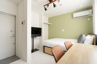 a room with a bed and a table with chairs at Luna\u4e21\u56fd in Tokyo