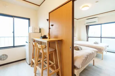 a room with a bed and a desk with a mirror at \u58a8\u7530\u533a\u76f4\u8fbe\u6cb3\u666f\u6c11\u5bbf in Tokyo