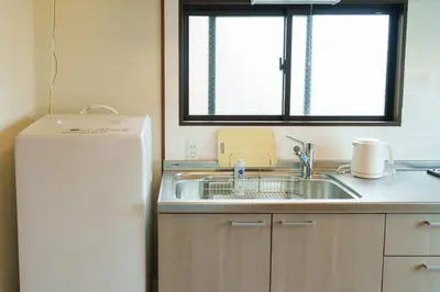 a kitchen with a sink and a refrigerator at \u58a8\u7530\u533a\u76f4\u8fbe\u6cb3\u666f\u6c11\u5bbf in Tokyo