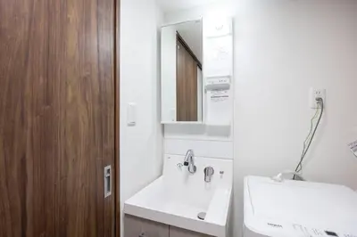 a white bathroom with a sink and a mirror at Fruit Elegant in Tokyo