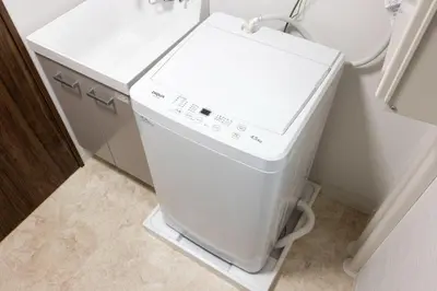 a small white washer and dryer in a bathroom at Fruit Elegant in Tokyo