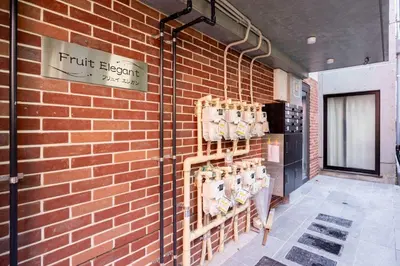 a brick wall with a sign that reads fruit elevator at Fruit Elegant in Tokyo