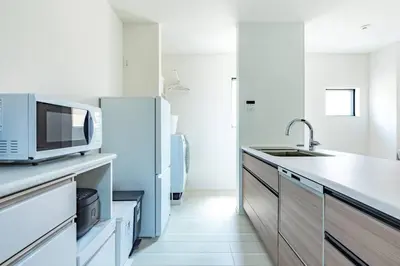 a white kitchen with a microwave and a refrigerator at \u60a0\u60a0\u4e4b\u5bb6 \u6c60\u888b\u5546\u4e1a\u533a 7\u5206\u949f\u6b65\u884c\u5230\u6c60\u888b\u8f66\u7ad9 3\u5c42\u72ec\u680b\u522b\u5885 \u5168\u65b0 3\u623f2\u5385\u53a8\u536b\u9f50\u5168 \u514d\u8d39\u8f66\u5e93 \u5948\u98de\u5f71\u9662 in Tokyo