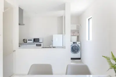 a white kitchen with a washing machine and a window at \u60a0\u60a0\u4e4b\u5bb6 \u6c60\u888b\u5546\u4e1a\u533a 7\u5206\u949f\u6b65\u884c\u5230\u6c60\u888b\u8f66\u7ad9 3\u5c42\u72ec\u680b\u522b\u5885 \u5168\u65b0 3\u623f2\u5385\u53a8\u536b\u9f50\u5168 \u514d\u8d39\u8f66\u5e93 \u5948\u98de\u5f71\u9662 in Tokyo