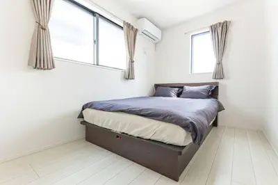 a bedroom with a bed and two windows at \u60a0\u60a0\u4e4b\u5bb6 \u6c60\u888b\u5546\u4e1a\u533a 7\u5206\u949f\u6b65\u884c\u5230\u6c60\u888b\u8f66\u7ad9 3\u5c42\u72ec\u680b\u522b\u5885 \u5168\u65b0 3\u623f2\u5385\u53a8\u536b\u9f50\u5168 \u514d\u8d39\u8f66\u5e93 \u5948\u98de\u5f71\u9662 in Tokyo