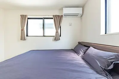 a bedroom with a bed and two windows at \u60a0\u60a0\u4e4b\u5bb6 \u6c60\u888b\u5546\u4e1a\u533a 7\u5206\u949f\u6b65\u884c\u5230\u6c60\u888b\u8f66\u7ad9 3\u5c42\u72ec\u680b\u522b\u5885 \u5168\u65b0 3\u623f2\u5385\u53a8\u536b\u9f50\u5168 \u514d\u8d39\u8f66\u5e93 \u5948\u98de\u5f71\u9662 in Tokyo
