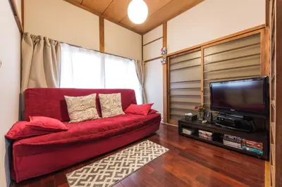 a red couch in a living room with a television at Samurai House - Vacation STAY 54179v in Tokyo