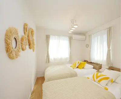 two beds in a room with white walls and windows at Jacky's House Yahiro in Tokyo