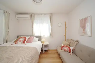 a living room with two beds and a couch at Jacky's House Yahiro in Tokyo