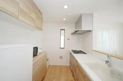 a white kitchen with a sink and a microwave at Jacky's House Yahiro in Tokyo
