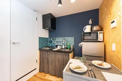 a small kitchen with a counter and a refrigerator at AsahiStay -Asakusa, Self check in & Well located house in Tokyo