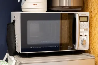 a microwave oven sitting on top of a refrigerator at AsahiStay -Asakusa, Self check in & Well located house in Tokyo