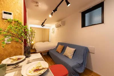 a living room with a blue couch and a table at AsahiStay -Asakusa, Self check in & Well located house in Tokyo