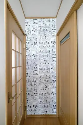 a hallway with a door and a wall covered inigraphy at Largo in Tokyo