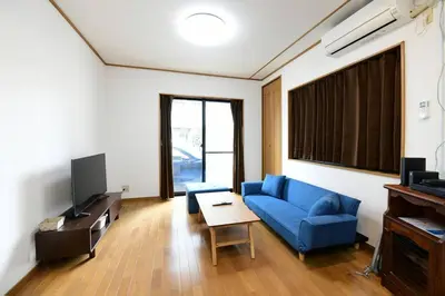a living room with a blue couch and a tv at Largo in Tokyo