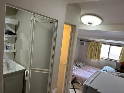 a bathroom with a shower and a bed in a room at \u5343\u99c4\u6728\u306e\u52c7 in Tokyo