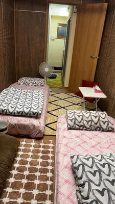 a room with two beds and a table and a door at \u5343\u99c4\u6728\u306e\u52c7 in Tokyo