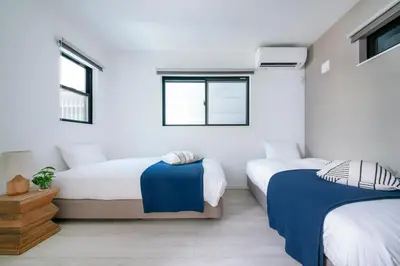 two beds in a room with white walls and windows at pufuka Higashi Mukojima 4 in Tokyo