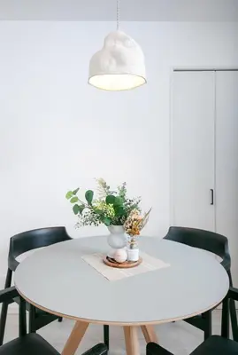 a white table with chairs and a vase of flowers at pufuka Higashi Mukojima 4 in Tokyo