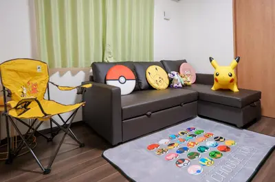 a living room with a black couch and a yellow chair at Room 202 - Itabashi Minamicho - Diamond Yu in Tokyo