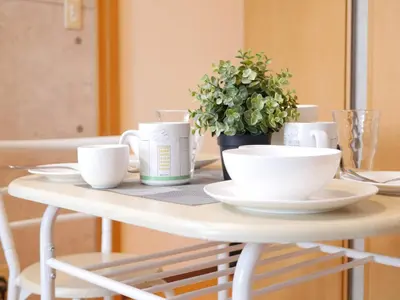 a white table with cups and saucers on it at Amika First301 AF31 in Tokyo