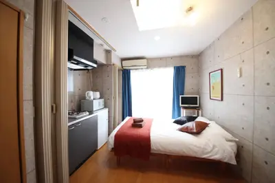 a small bedroom with a bed and a kitchen at Amika First301 AF31 in Tokyo