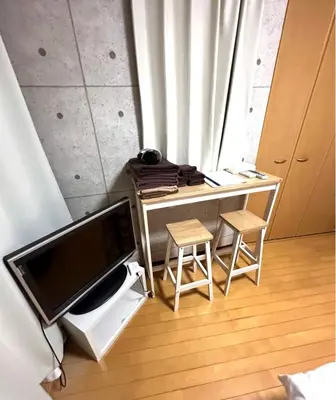 a desk with two stools and a television in a room at Amika First 303 AF33 in Tokyo
