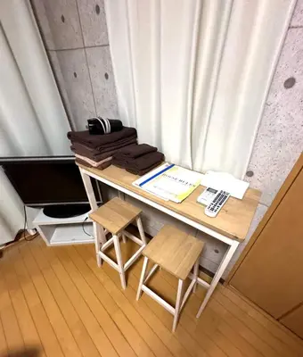 a table with two stools and a desk with a keyboard at Amika First 303 AF33 in Tokyo