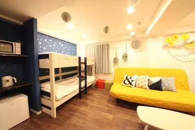 a bedroom with two bunk beds and a yellow bed at Shibuya Wave 101 in Tokyo