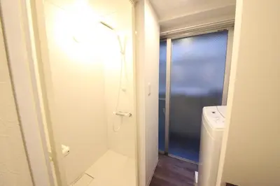 a bathroom with a shower and a washer and dryer at Shibuya Wave 101 in Tokyo