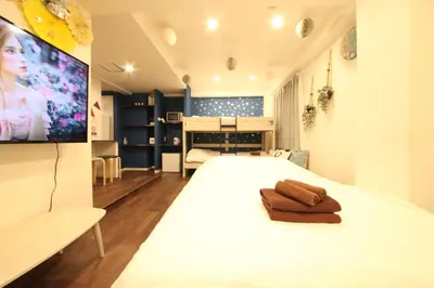 a bedroom with a white bed with a flat screen tv at Shibuya Wave 101 in Tokyo