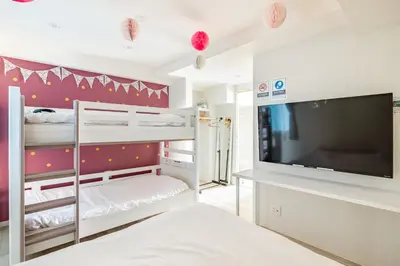 a room with bunk beds and a flat screen tv at Shibuya WAVE 201 in Tokyo