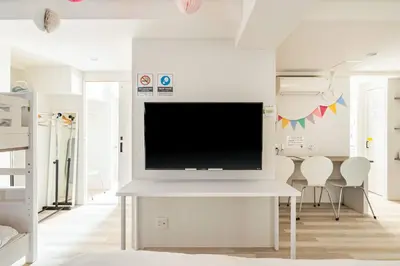 a living room with a flat screen tv on a white wall at Shibuya WAVE 201 in Tokyo