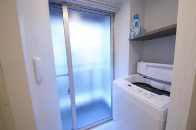 a washing machine in a small kitchen with a glass door at Shibuya WAVE 201 in Tokyo