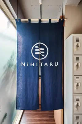 a blue curtain in a room with a nighthawk sign at NiHITARU Stay in Tokyo